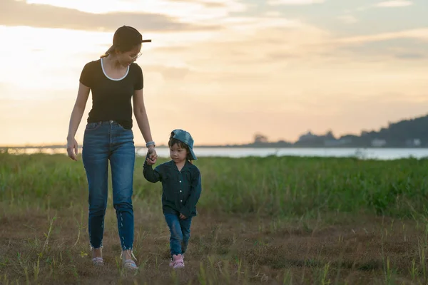Маленькая азиатская девочка, гуляющая на природе со своей мамой, Матерью Хол Лицензионные Стоковые Фото