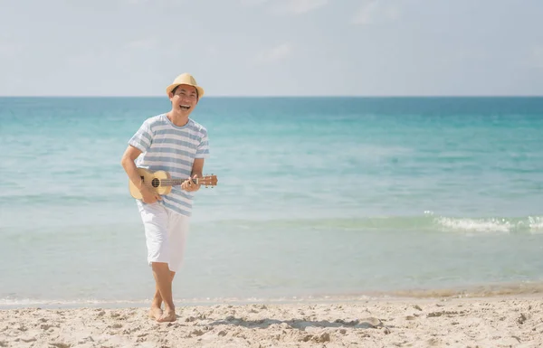 Asiático hombre jugando un ukelele y cantando con disfrutar en un tropical —  Fotos de Stock