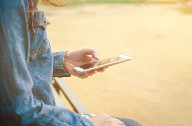 Kız akıllı phonea kullanarak kot ceketli