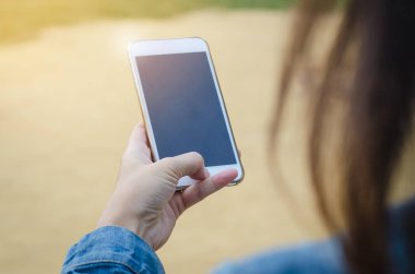 Kız akıllı phonea kullanarak kot ceketli