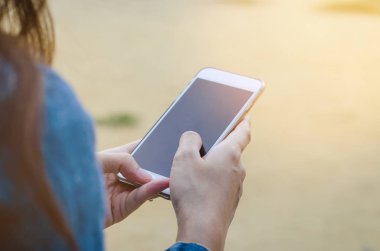 Kız akıllı phonea kullanarak kot ceketli