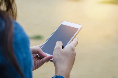 Kız akıllı phonea kullanarak kot ceketli