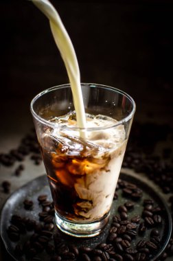 Süt buzlu espressoya dökülüyor.