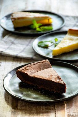 Çikolatalı keki yakın çekim siyah tabakta, tahta masada.