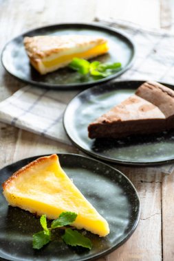 Çikolatalı keki yakın çekim siyah tabakta, tahta masada.