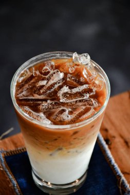 Ahşap masada çikolatalı lava kekiyle buzlu kahve.