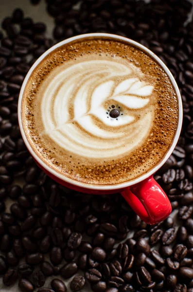 Heiße Latte Art Roten Becher Gegen Kaffeebohnen Stockbild