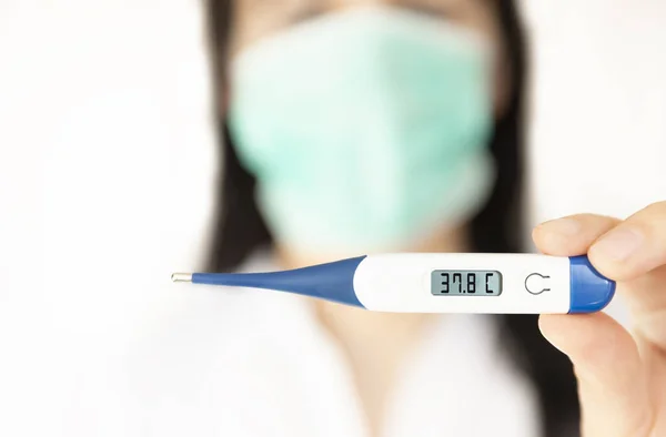 体温計を持っている女性看護師 コロナウイルスの医学的概念 — ストック写真