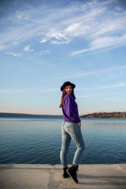 Şapkalı genç kadın poz veriyor.