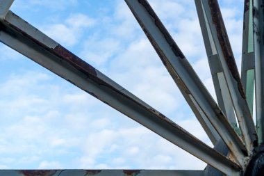 Bulutlu gökyüzü önünde eski paslı tekerlek