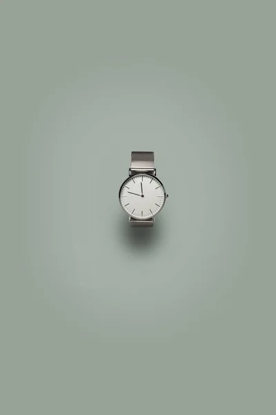 Zegarek srebrny z cienia na szarym tle — Zdjęcie stockowe