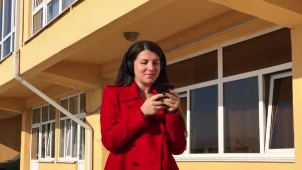 Fille marche avec des écouteurs et chanter la chanson — Video