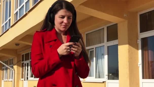 Fille marche avec des écouteurs et chanter la chanson — Video