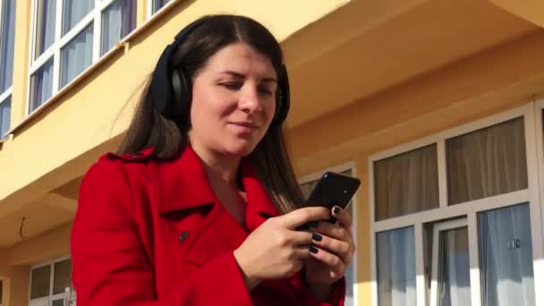 Menina andando com fones de ouvido e cantando a música — Vídeo de Stock