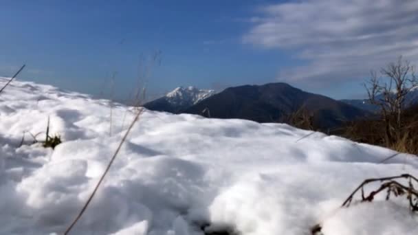 Sneeuw in de bergen, besneeuwde toppen, een dorp in de bergen — Stockvideo