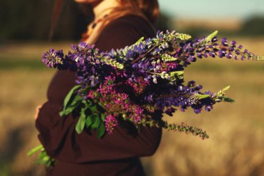 Bisiklet ve çiçeklerle yürüyen mutlu bir kadın / yaz tatili kavramı / doğayla uyum