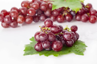 Beyaz zemin üzerinde yaprak izole kırmızı üzüm