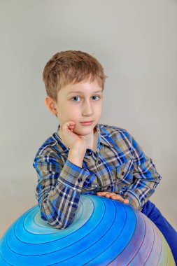 Sevimli beyaz çocuk, gri arka plan üzerinde ilköğretim okulu öğrenci portresi. 7 yıl birinci sınıf öğrencisi çocuk yaşlı.