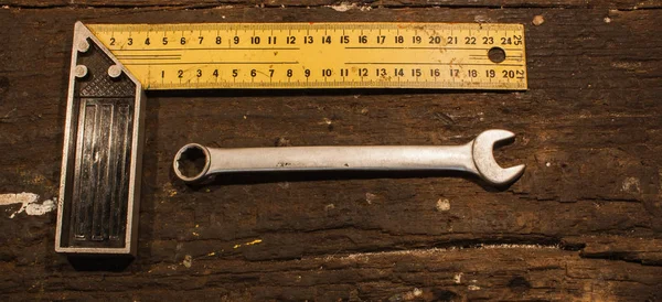 Schraubenschlüssel und Leine Zentimeter auf Holzgrund — Stockfoto