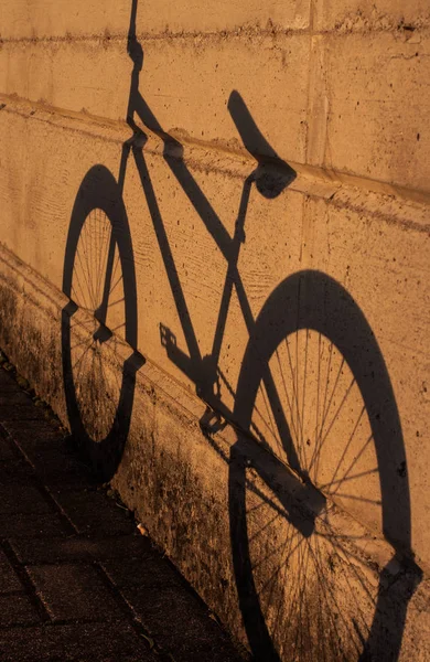 सूर्यास्ताच्या वेळी भिंतीवर सायकल सावली — स्टॉक फोटो, इमेज