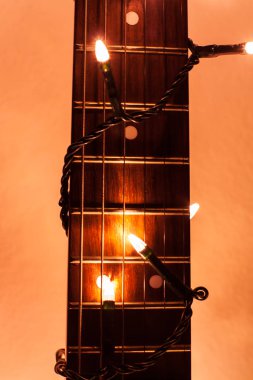 Gitar RIFF yılbaşı ışıkları önünde beyaz bac tarafından vurgulanan