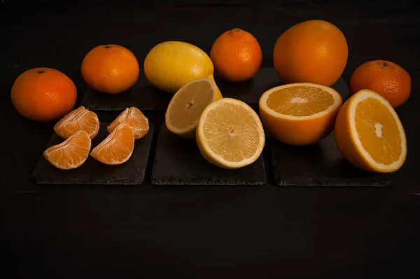 orange, half orange, lemon, half lemon, mandarin, mandarin slices on a black background