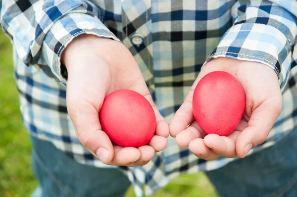 Пасхальная охота - два красных яйца в руках — стоковое фото