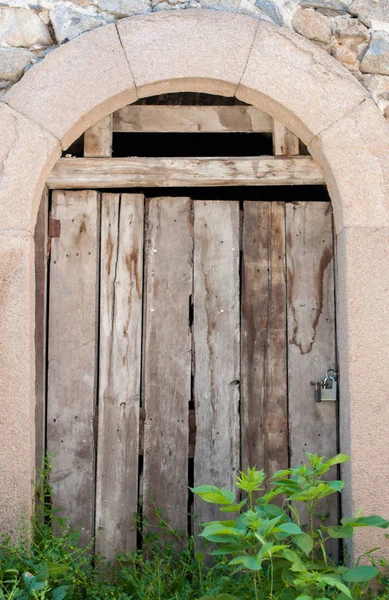 Vieja puerta de madera en la pared de piedra — Foto de Stock