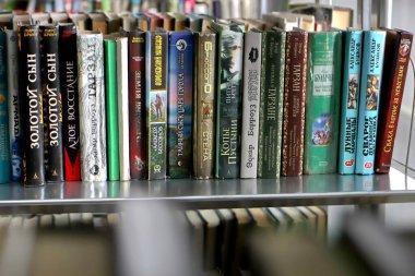 Kütüphanedeki raflarda bulunan kitaplar.