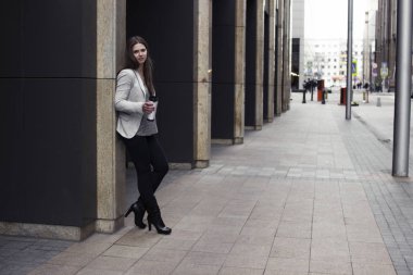 parlak bir ceket bir kız duvara yakın duruyor 