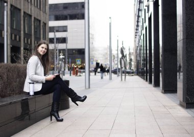 parlak bir ceket bir kız tabletle oturan s