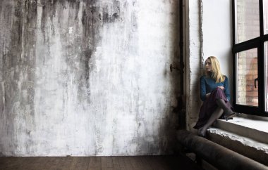 genç bir kadın bir pencere üzerinde oturur 