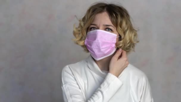 Młoda kobieta zdejmuje maskę medyczną. Kobieta oddycha głęboko i uśmiecha się patrząc w kamerę. Opieka zdrowotna i koncepcja medyczna. Kobieta cieszy się, że epidemia minęła 4k. — Wideo stockowe