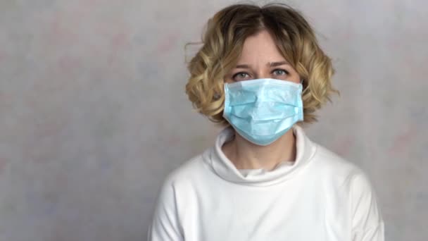 Young woman takes off medical mask. Female breathes deeply and smiling looking at camera. Health care and medical concept. Woman rejoices that the epidemic is over 4k — Stock Video