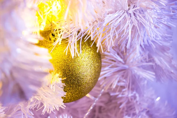 Closeup of white Christmas-tree with golden bauble hanging decor — Stock Photo, Image
