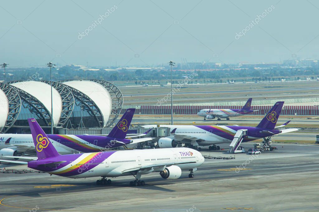 BANGKOK, THAILAND - MARCH 10, 2020: Airplanes from Thai Airways (TG) are parked their hub at passenger gate, connect to gate inside Suvarnabhumi International Airport Samutprakan. Thailand.