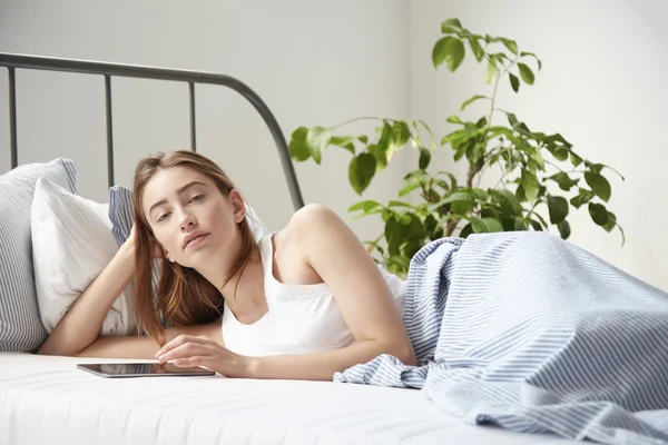 Kvinna ligger i sängen på morgonen — Stockfoto