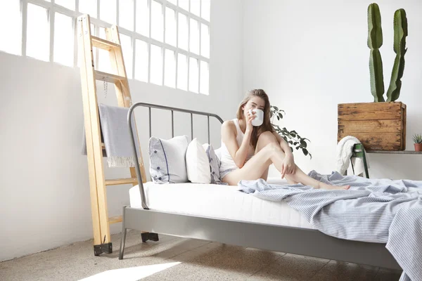 Donna che beve caffè del mattino a letto — Foto Stock