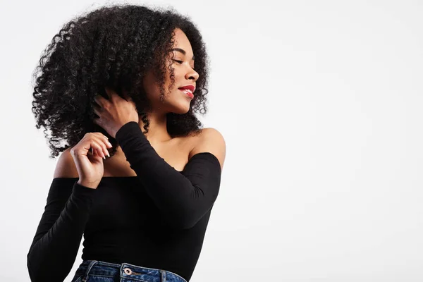 Чорна жінка торкається кучерявого волосся — стокове фото
