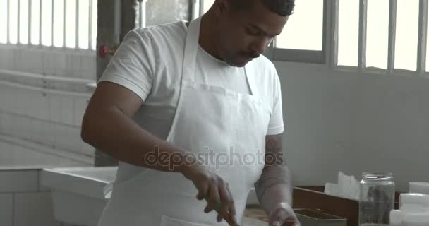 Чорний чоловік змішується в мисці на промисловій кухні — стокове відео