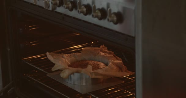 gros plan de mans chef main sortir un gâteau du four 