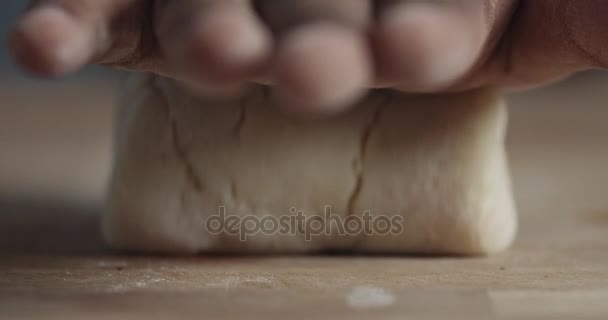 Fechamento em câmera lenta da mão do homem negro tira um rolo de massa do foco para o borrão — Vídeo de Stock