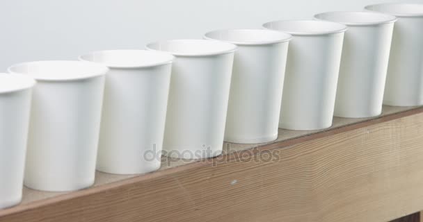 Ряд белых бланк бумажные стаканчики идет, чтобы расфокусироваться — стоковое видео