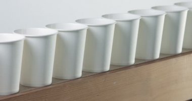 Pan kamera hareketi beyaz kağıt bardak çiğ gösterir