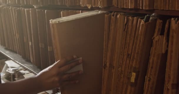 Man puts a folder on its place in shelf — Stock Video