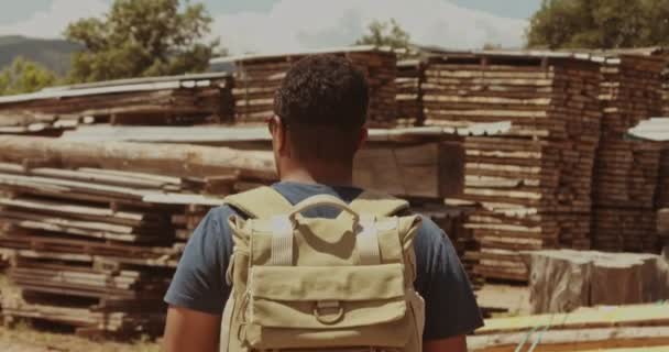 Gemengd ras man gaat vooruit door houten boerderij — Stockvideo