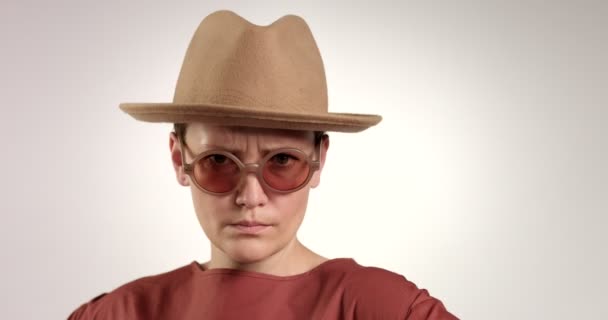 Şapka ve güneş gözlüğü şüpheye sonra ciddi kadında — Stok video