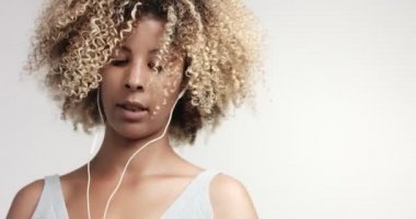 Güzellik karışık ırk kadın afro saçlı ve çilli earphones ve smartphone ile portre