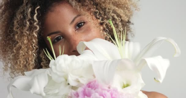 Beauty mixed race woman in studio with flowers — Stock Video