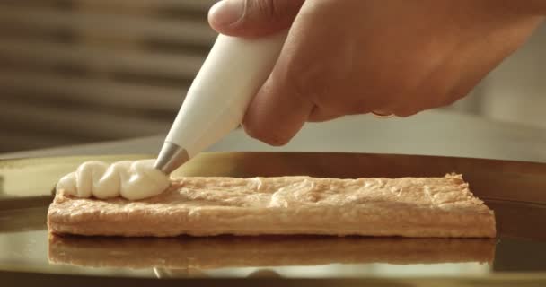 Noir chef mettre crem sur pâte feuilletée de sac à pâtisserie — Video